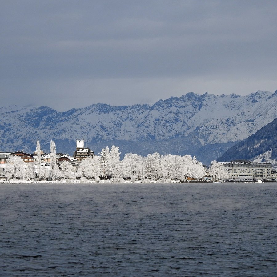 Zell am See ved Zeller See en vinterdag, med rimfrosne trær og snødekte fjell i bakgrunnen