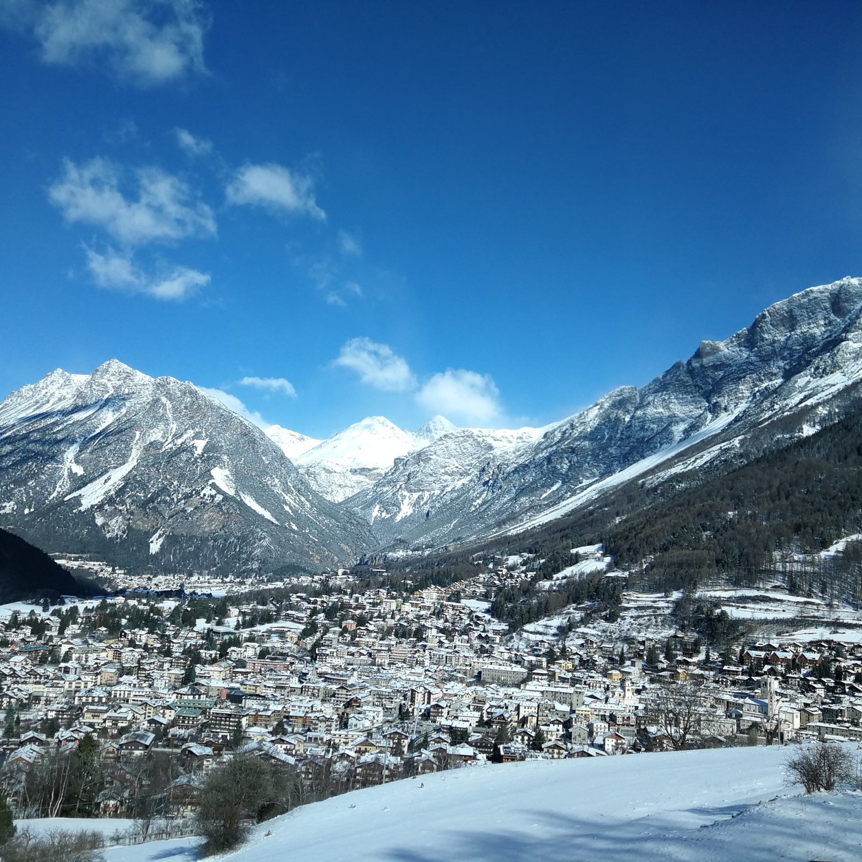 Panoramautsikt over Bormio i dalbunnen med snødekte fjell rundt